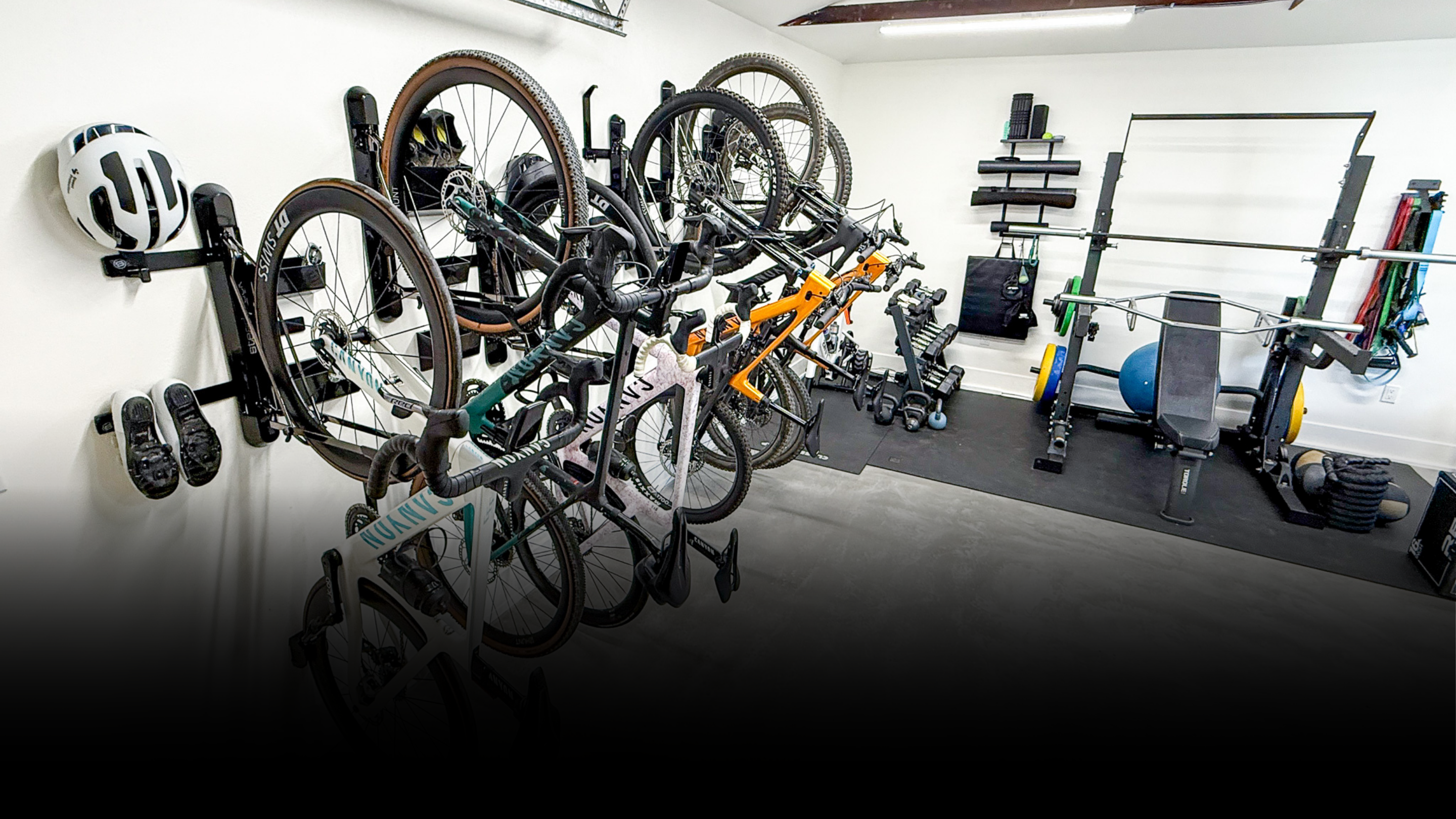 Bicycle rack with multiple bicycles in a room with gym equipment.