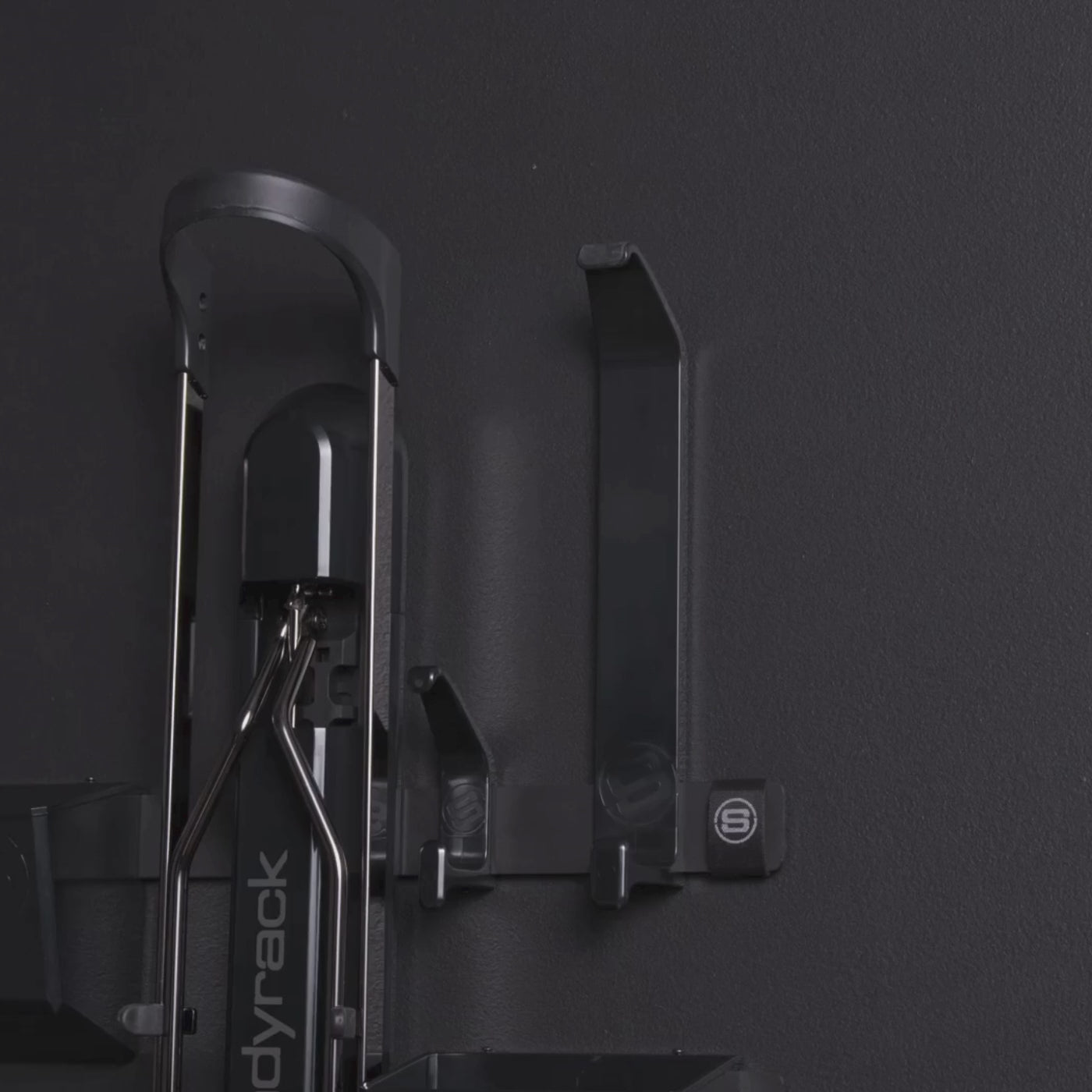 A person hanging a helmet on a black helmet hook.